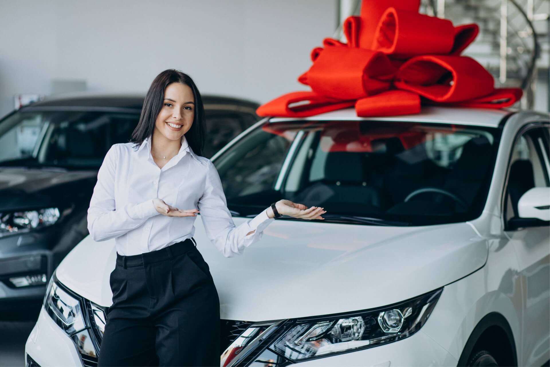 woman by car with big red bow